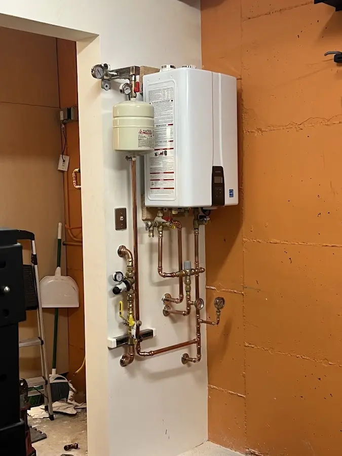 Plumbing technician inspecting water heater connections in Midland Park